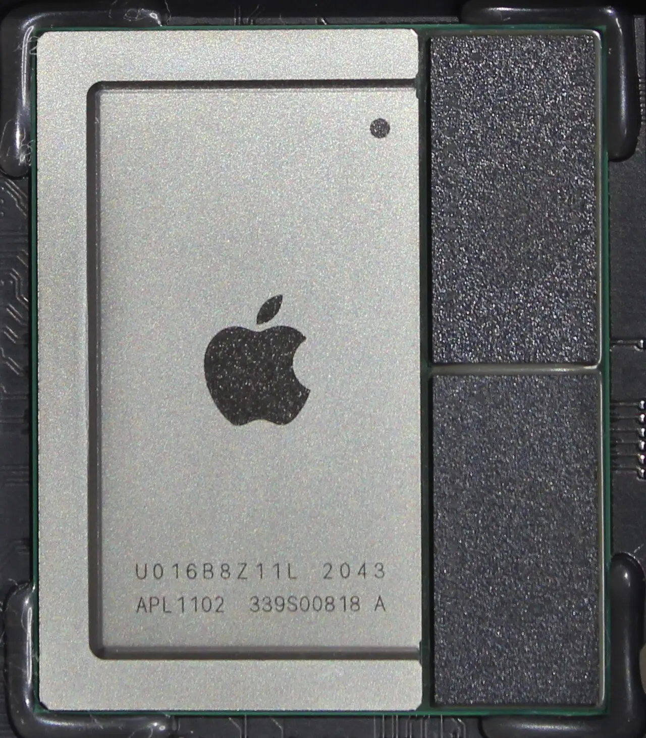 Close-up of an Apple M1 chip (marked APL1102) on the logic board of a 2020 Mac mini, with the two memory dies sharing the package