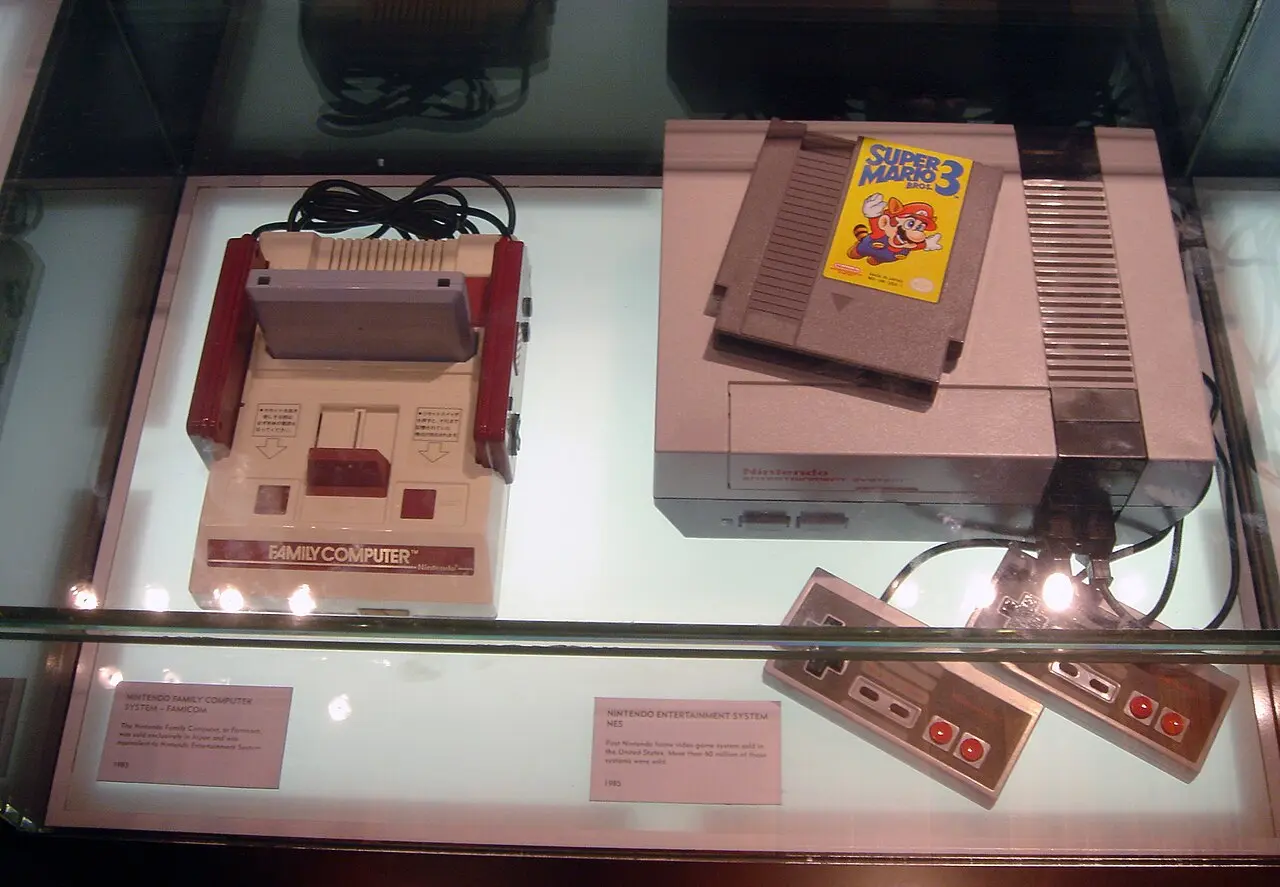 A Famicom and an NES displayed side by side in a case at the Nintendo World Store