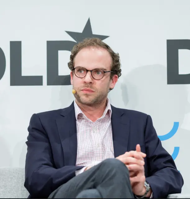 Carl Benedikt Frey seated on stage at a panel discussion (photographed in 2016)