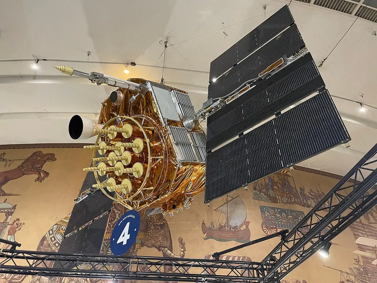 サンディエゴ航空宇宙博物館に展示された GPS 衛星 GPS-0012。金色の断熱材に覆われた本体と太陽電池パネル