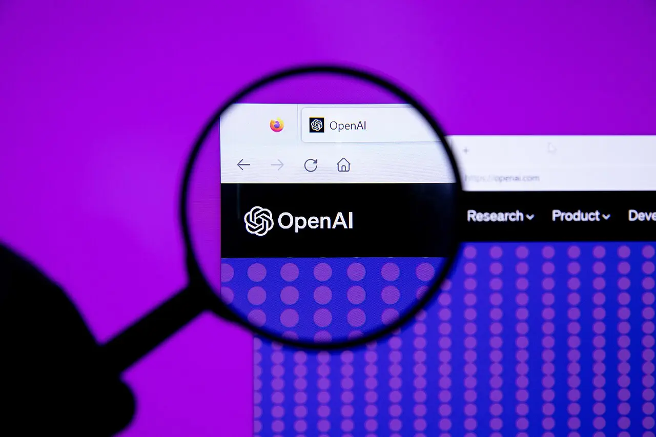 虫眼鏡越しに拡大された、ブラウザに表示された OpenAI のサイトのロゴ