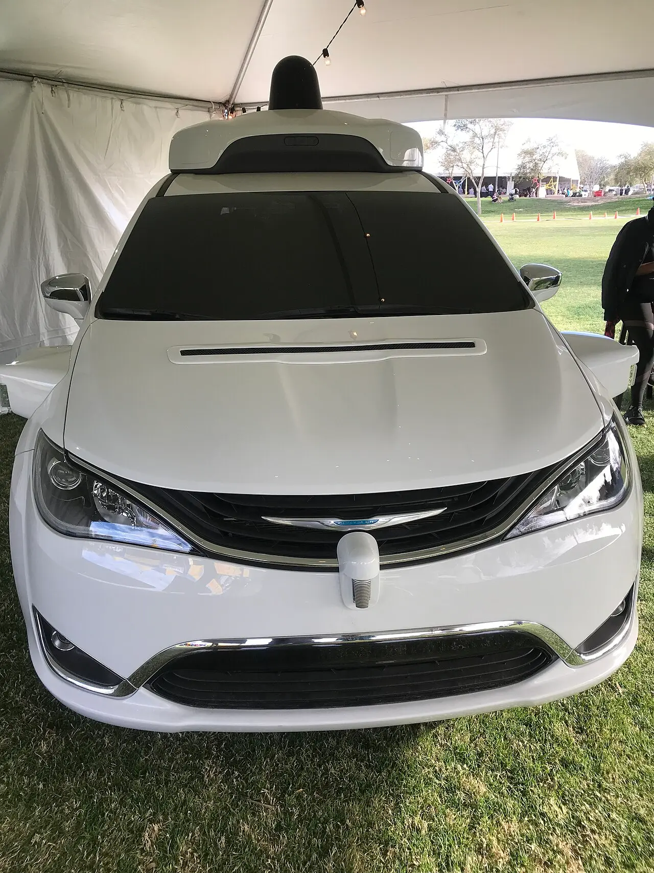 A Waymo self-driving minivan (Chrysler Pacifica) on display in Chandler, Arizona, with a lidar dome on the roof and sensors around the body