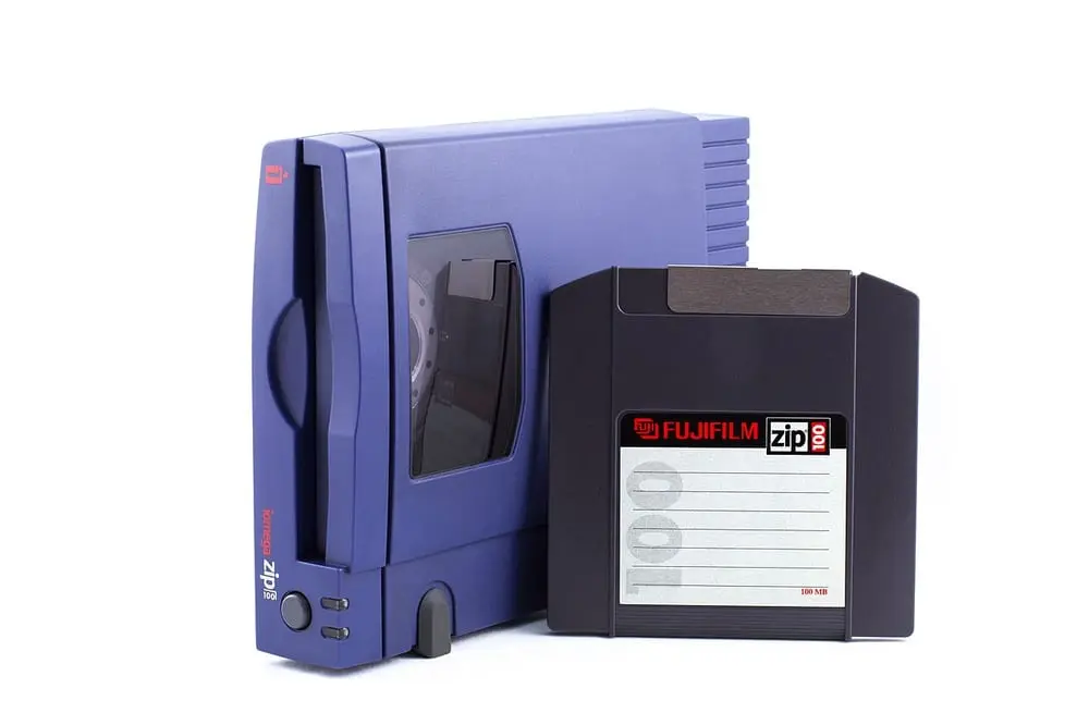 A blue external Iomega Zip 100 drive with a 100 MB Zip disk made by Fujifilm