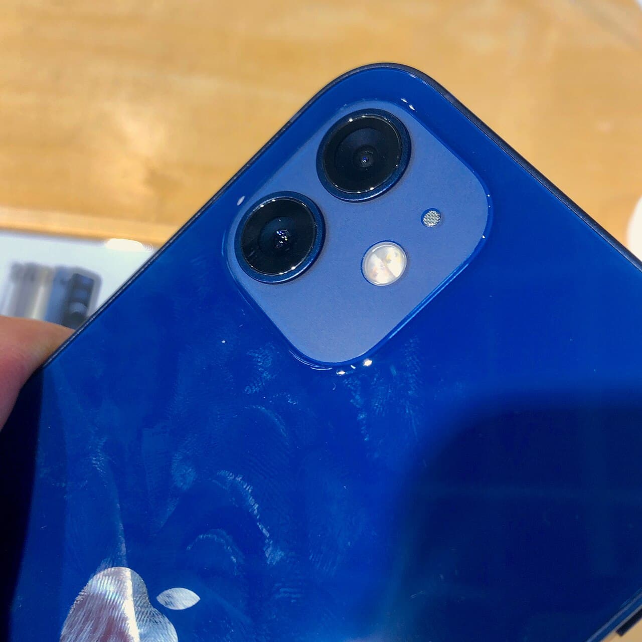 The back of a blue iPhone 12, showing its dual camera and the flat sides that recall the iPhone 4