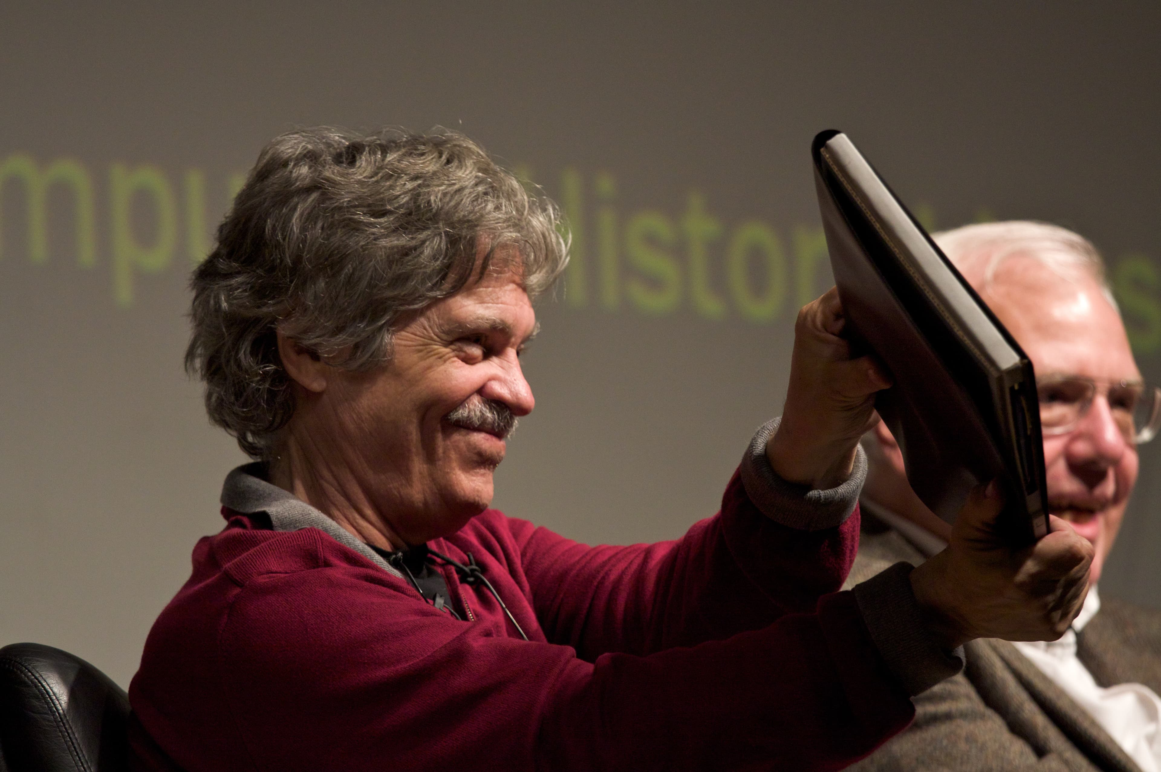 Portrait of Alan Kay holding a Dynabook prototype